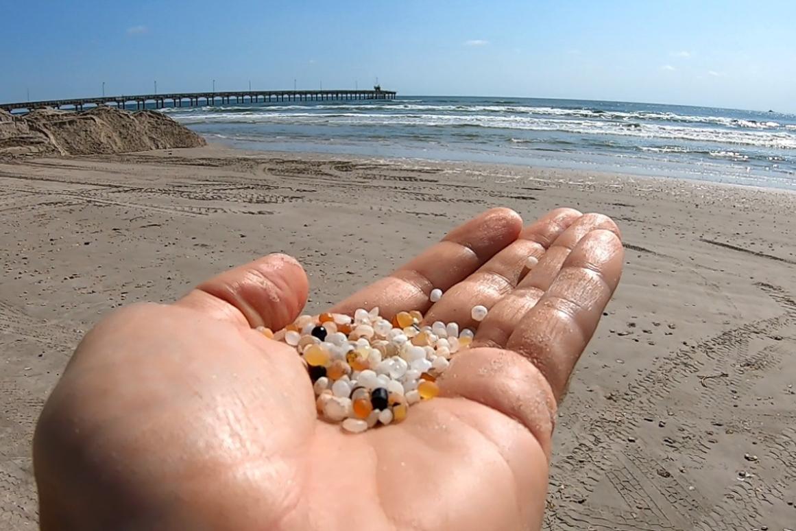 nurdles in hand on Texas beach